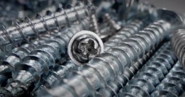 Süper makro vidalar, cıvatalar somun ve cıvata parçaları, metal yaylar, bir yığın bağlayıcılar. Makro vidalar, çelik vidalar kavramı. Tahtayı vidayla delmeye çok yakın..