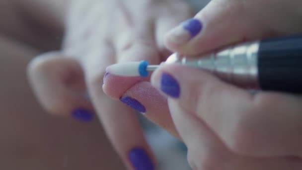 Manicurista elimina esmalte de uñas púrpura en sus manos. proceso de manicura en casa. Quitar el esmalte de uñas con un cortador de uñas. — Vídeo de stock