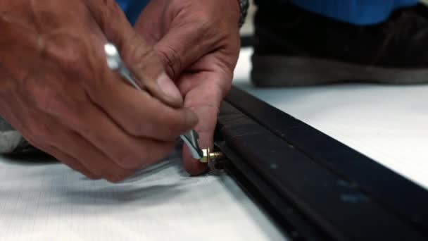 Tangan seorang pekerja yang melepas sekrup baut dengan kunci dari bingkai logam. Seorang pria menggunakan kunci pas logam untuk menghapus sekrup dari sepotong logam di toko kayu nya. — Stok Video