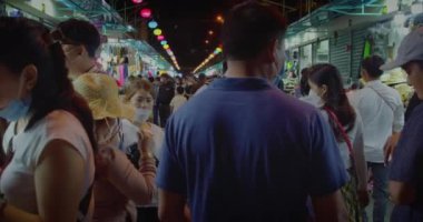 Yeni Yıl pazarındaki turistler, Ay Yeni Yılı kutlamaları sırasında Asya 'daki sokak pazarında maske takan hatıra eşyaları seçip satın alıyorlar. Asya Vietnam, Nha Trang, 3 Ocak 2022