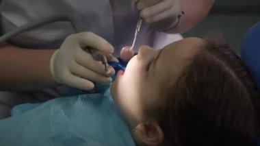 Diş hekimliği, kadın diş hekimi klinikteki küçük kız çocuğuna diş tedavisi. Kadın profesyonel doktor Stomatolog iş başında. Konsept Diş Denetimi.