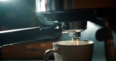 Kahve espresso hazırlama, kahve makinesiyle yapılmış en kaliteli İtalyan espresso kahvesi kahve fincanına düşer. Filtre tutacağı kullanılarak. Taze taze kahve..