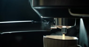 Kahve makinesinden fincana kahve dökülüyor. Ev yapımı sıcak Espresso. Filtre tutacağı kullanılıyor. Taze kahve akıyor. Sabahları kavrulmuş sade kahve içmek..
