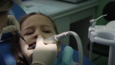 Diş hekimliği, kadın diş hekimi klinikteki küçük kız çocuğuna diş tedavisi. Kadın profesyonel doktor Stomatolog iş başında. Konsept Diş Denetimi.