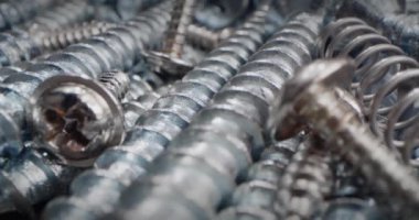 Tahtayı vidayla delmeye çok yakın. Makro vidaları, vidaları, cıvataları, cıvataları, metal yayları ve bir yığın bağlayıcıyı kapatır. Makro için vida kavramı, çelik vidalar.