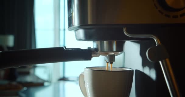 Koffiestroom uit machine in beker gieten. Thuis maken van hete Espresso. Filterhouder gebruiken. Frisse gemalen koffie. Drinken geroosterde zwarte koffie in de ochtend. — Stockvideo