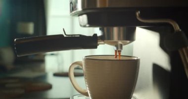 Kahve makinesinden fincana kahve dökülüyor. Ev yapımı sıcak Espresso. Filtre tutacağı kullanılıyor. Taze kahve akıyor. Sabahları kavrulmuş sade kahve içmek..