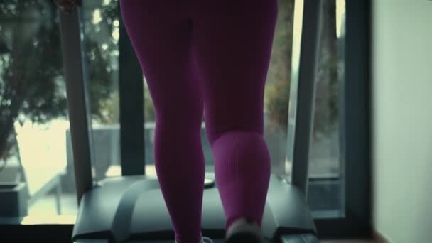 Pasująca kobieta trenująca pośladki na symulatorze sportu. Pretty sportowy dziewczyna ubrana w różowe legginsy posiadające pośladki ćwiczenia centrum sportu.Sport kobieta trening nogi zgięcie na bieżni w siłowni. — Wideo stockowe