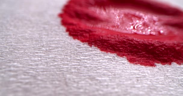 Красная кровь концепция. Красная кровь капает на белую ткань, кровь впитывается в белую бумажную салфетку, макроснимок. — стоковое видео