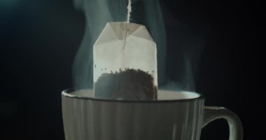 Çay poşeti beyaz bir fincan çay. Sabah çayı yapıyorum. 4K ve HD 'de mevcut. Bu çay videosu tarif ve yemek projeleri için uygundur. Önizlemeyi buraya bedavaya indir.