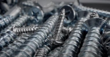 Süper makro vidalar, cıvatalar somun ve cıvata parçaları, metal yaylar, bir yığın bağlayıcılar. Makro vidalar, çelik vidalar kavramı. Tahtayı vidayla delmeye çok yakın..