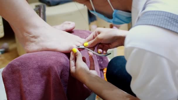 Beautician gör proceduren, förbereder och behandlar klienterna spik med vätska för att ta bort gamla nagellack från fingrarna innan pedikyr. — Stockvideo