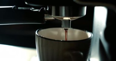 Ev yapımı sıcak Espresso. Filtre tutacağı kullanılıyor. Taze kahve akıyor. Kahve makinesinden fincana kahve dökmek. Sabahları kavrulmuş sade kahve içmek..