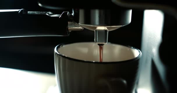 Casa a fare Espresso caldo. Utilizzo del portafiltro. Caffè macinato fresco che scorre. Versare il flusso di caffè dalla macchina in tazza.Bere caffè nero torrefatto al mattino. — Video Stock