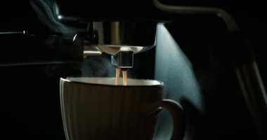 Kahve makinesi bardağı dolduruyor. Kahve makinesiyle kahve yapıp fincana koymak, otomatik kahve makinesinden çıkan espresso kahvesi. Kahvaltıda içecek.