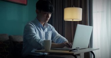 Yorgun ofis çalışanı masabaşı işlerinden sonra gözlüğünü çıkarıp dinleniyor. Genç ve çekici Asyalı Vietnamlı adam ev veri analisti veri bilimci şirketinde masa kitabı üzerinde çalışmakla meşgul..