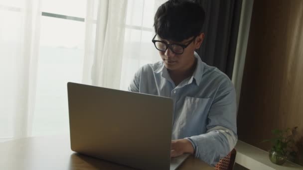 Молодой привлекательный азиатский вьетнамский мужчина занятой рабочий компьютер или смарт-планшет на домашнем ноутбуке в независимом аналитике данных, ученый по информатике для бизнеса. — стоковое видео