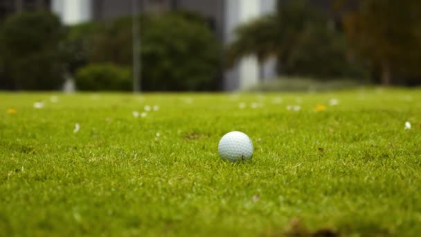 Człowiek grający w golfa na polu golfowym w mieście, kołyszący się i uderzający piłkę golfową w zwolnionym tempie. Golf Ball na zielono w polu golfowym uderzając piłkę golfową do otworu dla Birdie score.Cinematic Slow motion materiał — Wideo stockowe