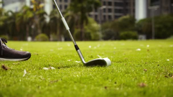 Hombre jugando al golf en el campo de golf en la ciudad, balanceo y golpear la pelota de golf en cámara lenta. Hermoso golpe en la pelota en el campo verde vuela en el agujero para el pajarito. — Vídeos de Stock