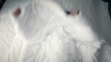 Mutlu, neşeli, beyaz pijamalı küçük bir kızın portresi. Sabah uyanır, ailesine gülümserken bakar. Kahkahalar atar ve tekrar battaniyenin altına saklanır..