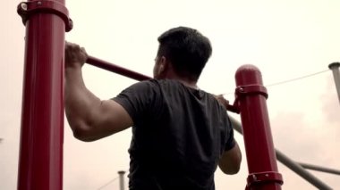 Fitness Spor Sokağı Antrenmanı. Sporcu Chin Up açık havada idman yapıyor. Çekme çubuğunda beden eğitimi. Halka açık spor salonunda kas yap. Sağlıklı adam barfiks egzersizinde. Çene yukarı, göğüs yukarı.