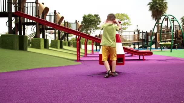 Happy lucu anak ayunan ayunan di taman, anak kecil, ayunan taman bermain pada hari yang cerah, seorang anak ceria mempercepat ayunan ke depan dalam lingkaran, anak tertawa dan tersenyum saat bermain di taman kota. — Stok Video