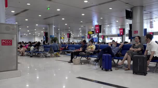 Le persone con maschere mediche di coronavirus aspettano in fila per effettuare il check-in per un volo all'aeroporto di Ho Chi Minh, Asia, Saigon, Vietnam, 10 aprile 2022 — Video Stock