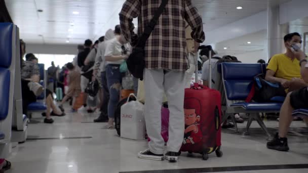 Pessoas em máscaras médicas do coronavírus esperam na fila para fazer o check-in para um voo no aeroporto de Ho Chi Minh, Ásia, Saigão, Vietnã, 10 de abril de 2022 — Vídeo de Stock