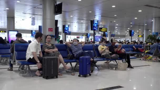 Le persone con maschere mediche di coronavirus aspettano in fila per effettuare il check-in per un volo all'aeroporto di Ho Chi Minh, Asia, Saigon, Vietnam, 10 aprile 2022 — Video Stock