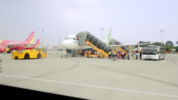 Ver aviões filmados de dentro de um ônibus do aeroporto como os passageiros estão sendo carregados, entregando as pessoas para os aviões depois de check-in para voo no aeroporto de Ho Chi Minh, Ásia, Saigon, Vietnã, 10 de abril de 2022 — Vídeo de Stock