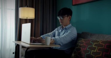 Genç, çekici Asyalı Vietnamlı iş bilgisayarı ya da evde bilgisayardaki akıllı tablet serbest veri analisti, iş dünyasından veri bilimci.