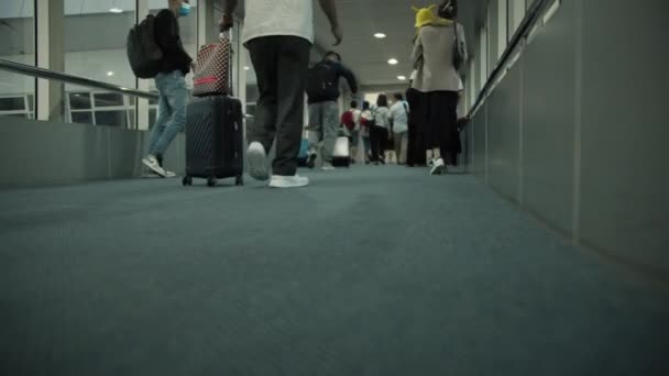 Soft focus Passagiers stappen uit het vliegtuig door middel van speciale mouw, schieten vanaf de bodem pakurs op de luchthaven, mensen met koffers van vlucht Ho Chi Minh City, Azië, Saigon, Vietnam, 10 april 2022 — Stockvideo