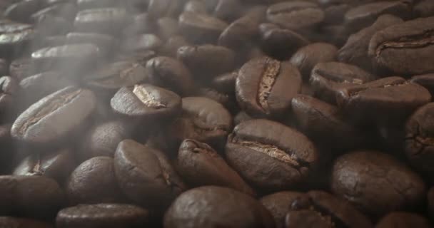 Macro schoot roosterende koffiebonen, gefilmd in een donkere sleutel de rook afkomstig van het roosteren van koffiebonen. Geurende koffiebonen zijn geroosterde rook komt van koffiebonen. — Stockvideo