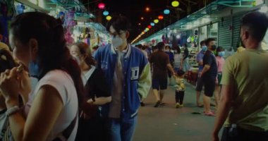 Yeni Yıl pazarındaki turistler, Ay Yeni Yılı kutlamaları sırasında Asya 'daki sokak pazarında maske takan hatıra eşyaları seçip satın alıyorlar. Asya Vietnam, Nha Trang, 3 Ocak 2022