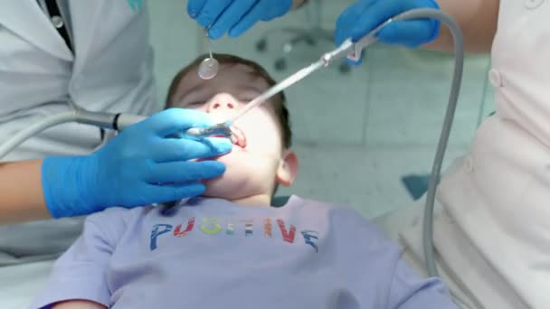 Koncepcja badania dentystycznego. Dentysta z dziećmi. Opieka zdrowotna i koncepcja medycyny.Dentystka bada zęby dziecka małego chłopca w klinice. Zawodowy dentysta w pracy. — Wideo stockowe
