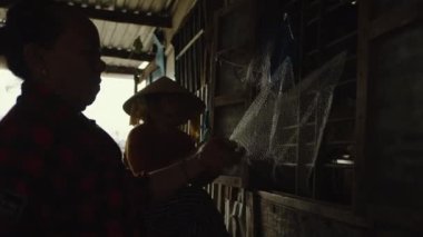 Hon Tre 'deki bir köyde balık ağı diken Vietnamlı bir kadın büyük bir balıkçı adasıdır ve Vietnamca' da önemli bir deniz ürünleri çiftliği endüstrisi vardır. Asya, Nha Trang, Vietnam, 15 Mayıs 2022