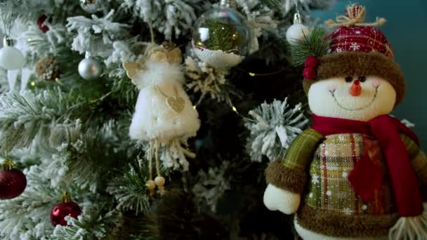 Gros plan des mains des enfants décorant l'arbre de Noël avec des boules sur le fond de lumières festives lumineuses. enfants décorant un sapin de Noël. — Video