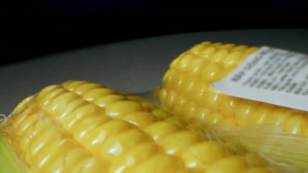 Cosecha de maíz. Fotografía macro de mazorcas de maíz envasadas y envueltas en una bolsa de palets para la venta. Maíz dorado en cuero con un precio en el paquete. Producto ecológico, jardinería ecológica — Vídeos de Stock
