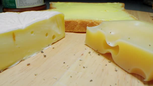 Detalhe de close-up queijo parmesão e camembert e um pedaço de pão com manteiga, close-up. Conceito de café da manhã ou almoço - imagens 4K — Vídeo de Stock