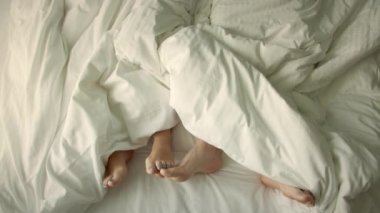 Yatakta birkaç sevişme. Evlilik, aile, aşk. Çerçevede sadece ayak var. Evlilik, aile, aşk, seks konsepti. Sabah 4-K 'da..