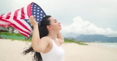 Vatanseverlik kavramı, bağımsızlık günü. Gülümseyen mutlu kadın gözlerini kapatıyor. Elinde ulusal Amerikan bayrağını tutuyor.