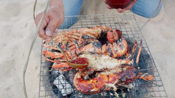 龙虾商贩 渔夫用炭火煮龙虾 煮新鲜龙虾 一个男人用红酱油给已经煮熟的龙虾加润滑油 — 图库视频影像