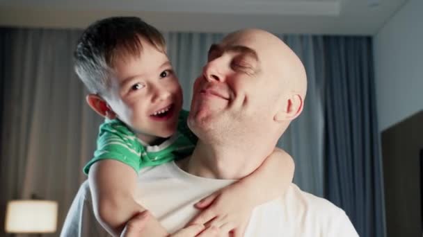 愛情に満ちた幸せなかわいい子供の魅力的な子供の肖像画 息子は抱きかかえて父親とキスをします 父の日 家族の絆のシンボル — ストック動画