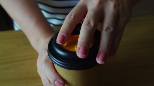 指にポーズマニキュアをかけた女性がコーヒーを飲みながら紙コップを占有し ふたを開けた 一日のためのエネルギーブースト — ストック動画