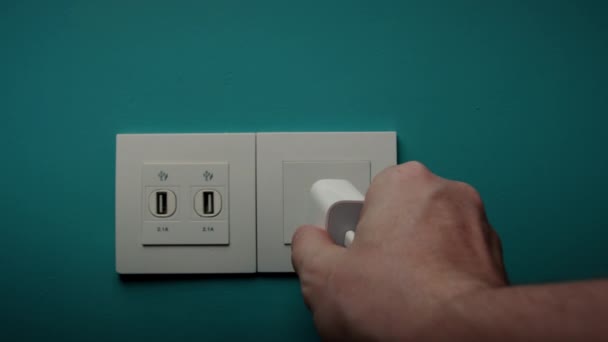 Homem Insere Tomada Elétrica Uma Parede Azul — Vídeo de Stock