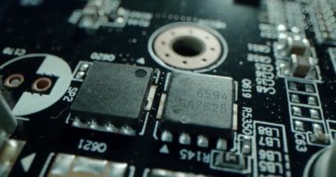 Macro dolly shot side view of a computer electrical circuit with cip, slots, microchip and microprocessors, black board with transistors and microchips. Close up detail of electronic components on PC