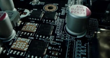 Macro dolly shot side view of a computer electrical circuit with cip, slots, microchip and microprocessors, black board with transistors and microchips. Close up detail of electronic components on PC