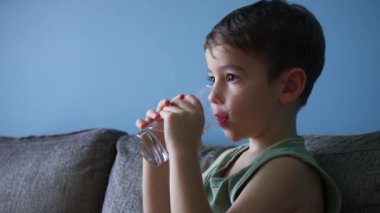 Şirin iki küçük çocuk süt içiyor, sağlıklı besleniyor çocuk kahvaltı yapıyor çocuk rüya görüyor. Çocuklar evde kanepede oturup televizyon izlerken yoğurt içiyorlar.