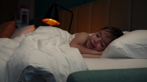 6歳の少年はカニの中で甘い眠りにつき 眠りにつく その側に眠っている子供の赤ちゃんのクローズアップ顔 真夜中に眠ってる赤ん坊を撃った ベッドで寝てる赤ん坊 — ストック動画