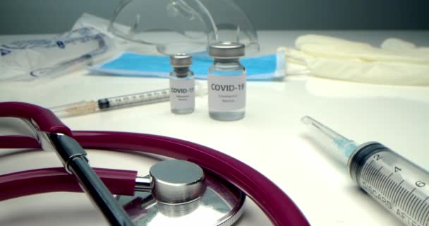 Covid 19に対するワクチン コロナウイルスに対するワクチンと近くの様々な注射器 医療機器 保護マスクが開発されています — ストック動画